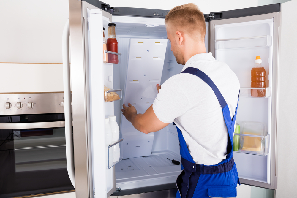 Certified technician repairing a refrigerator in Winnipeg